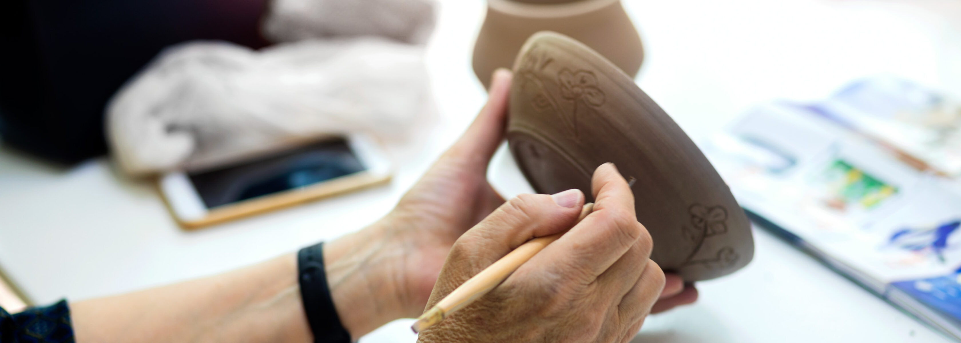 hands marking up a ceramic bowl.