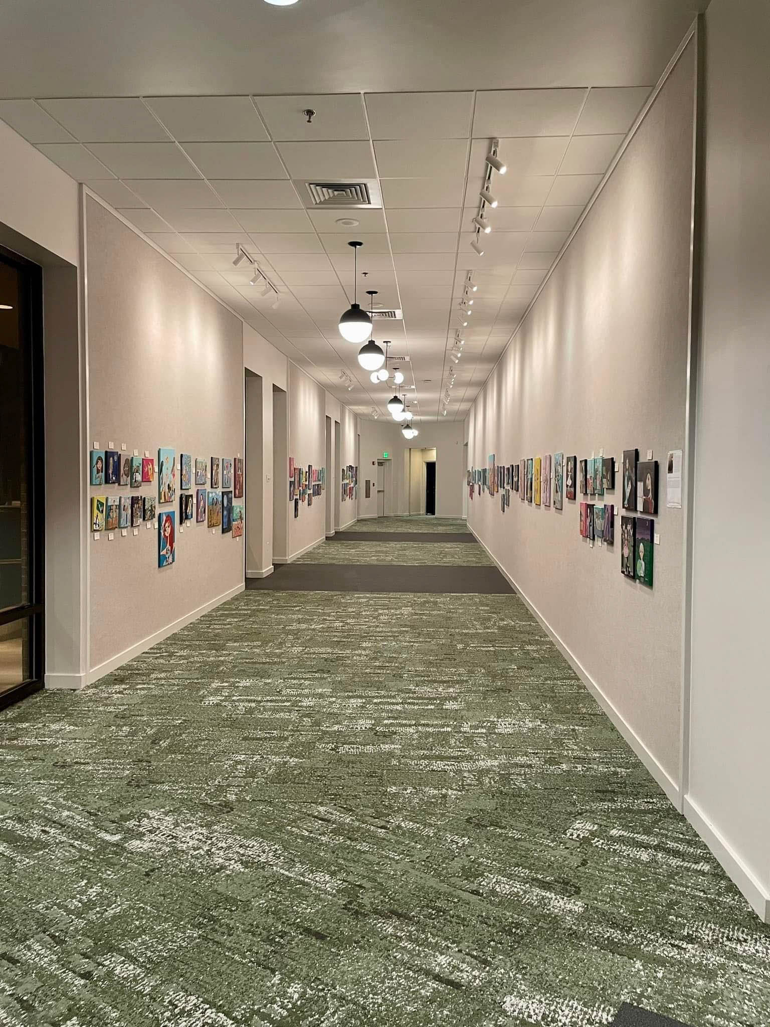 a hallway with art on the walls all the way down.